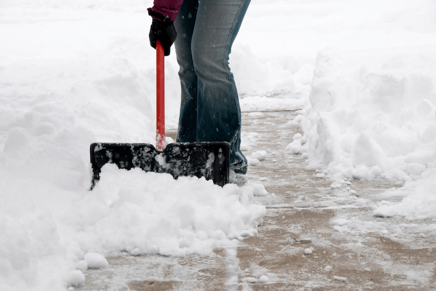 Eine Person räumt Schnee aus der Einfahrt